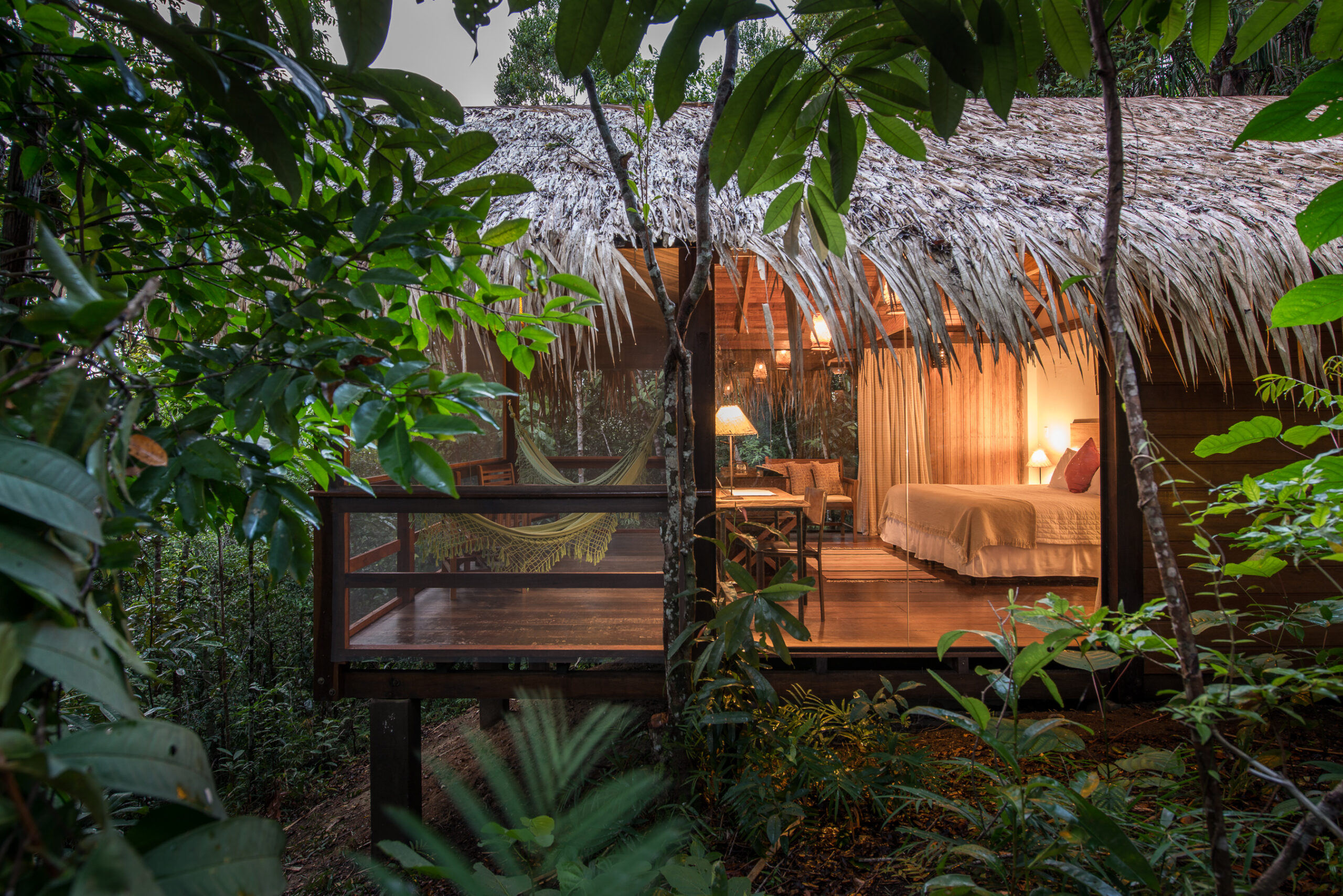 Comfortable Amazon jungle lodge with a thatched roof nestled in the tropical rainforest. 