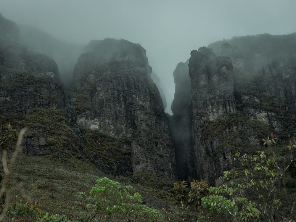  Imposing, steep rock faces partially covered by thick mist at Pico da Neblina National Park.