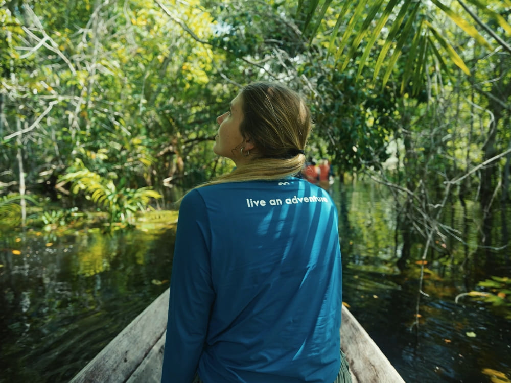 A traveler explores the flooded forests of the Amazon Rainforest by canoe during the high water season. A traveler explores the flooded forests of the Amazon Rainforest by canoe during the high water season.