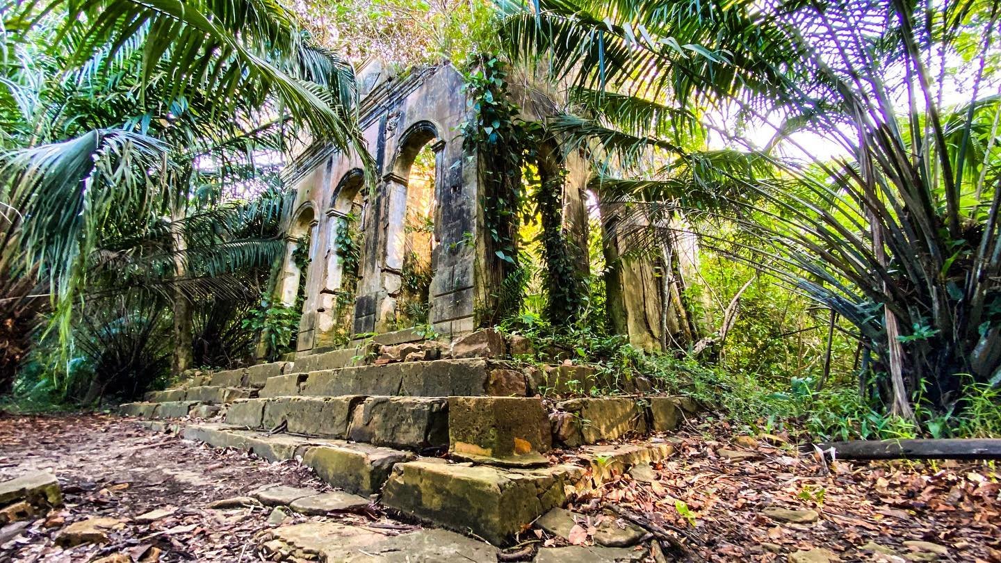 Jungle slowly reclaiming what history left behind. Moss-covered stone arches and crumbling steps of abandoned colonial ruins engulfed by tropical vegetation, visited on an Amazon Cruise Trip in Brazil