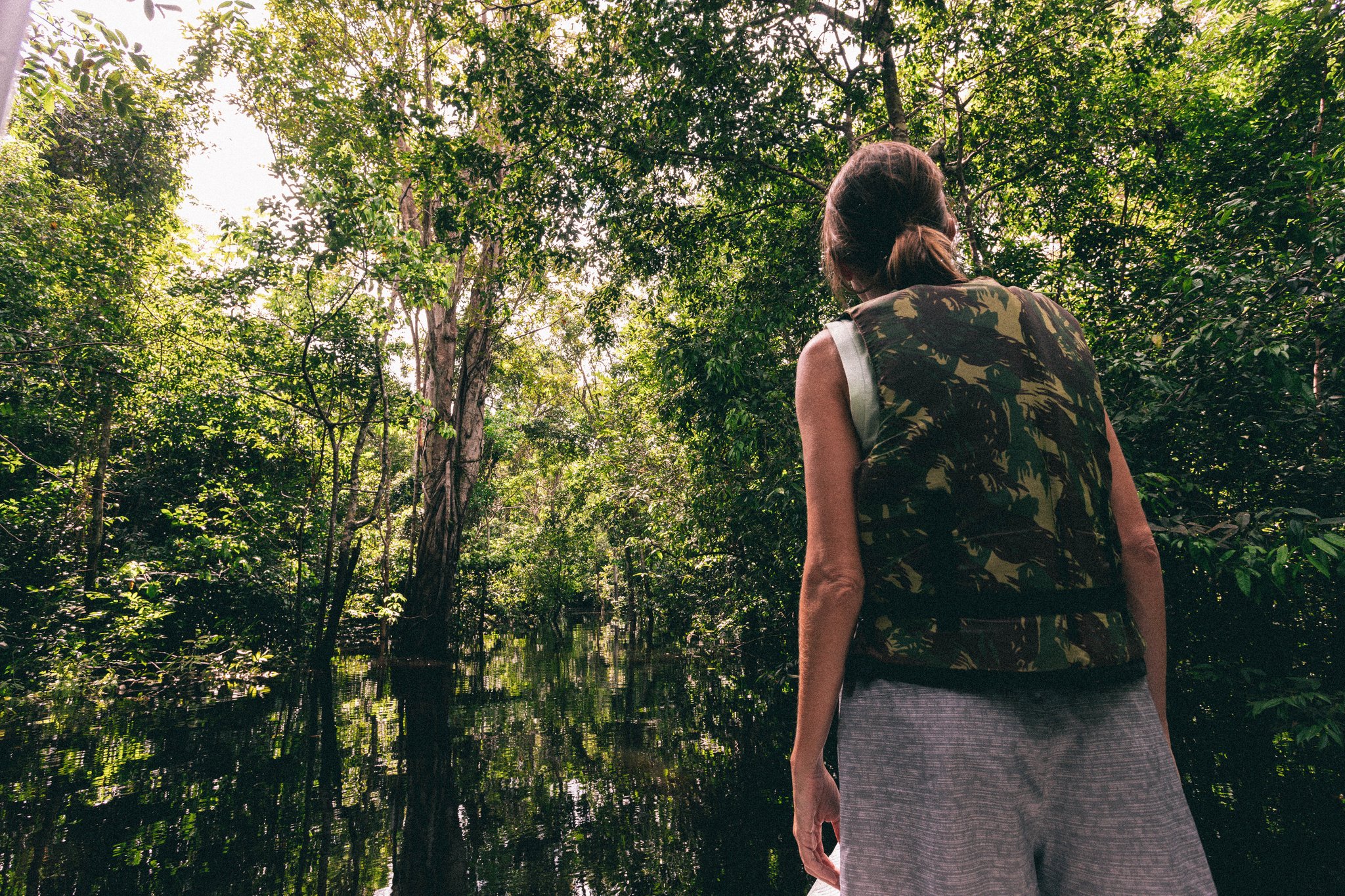A traveler on a boat tour through the flooded forest of the Anavilhanas archipelago in the Brazilian Amazon