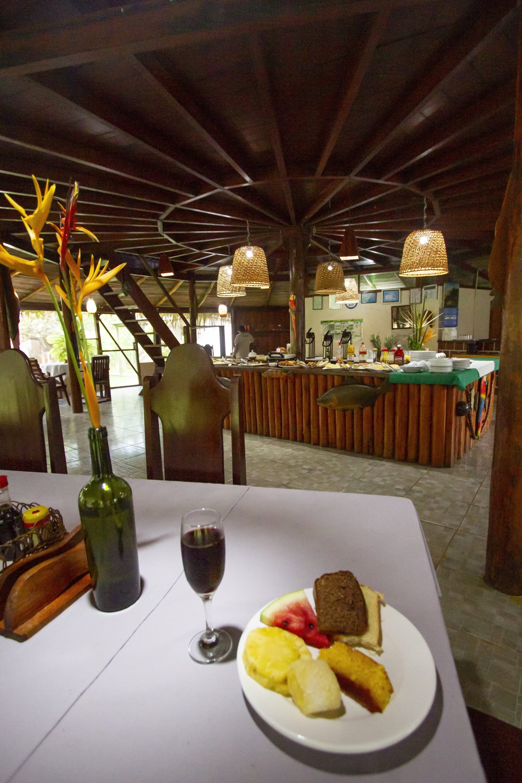 A slice of cake, fresh fruit and a glass of wine to close the day in style. Photo: David Nascimento @ Plate of cake and fresh fruit with a glass of wine on a table in the lodge dining hall