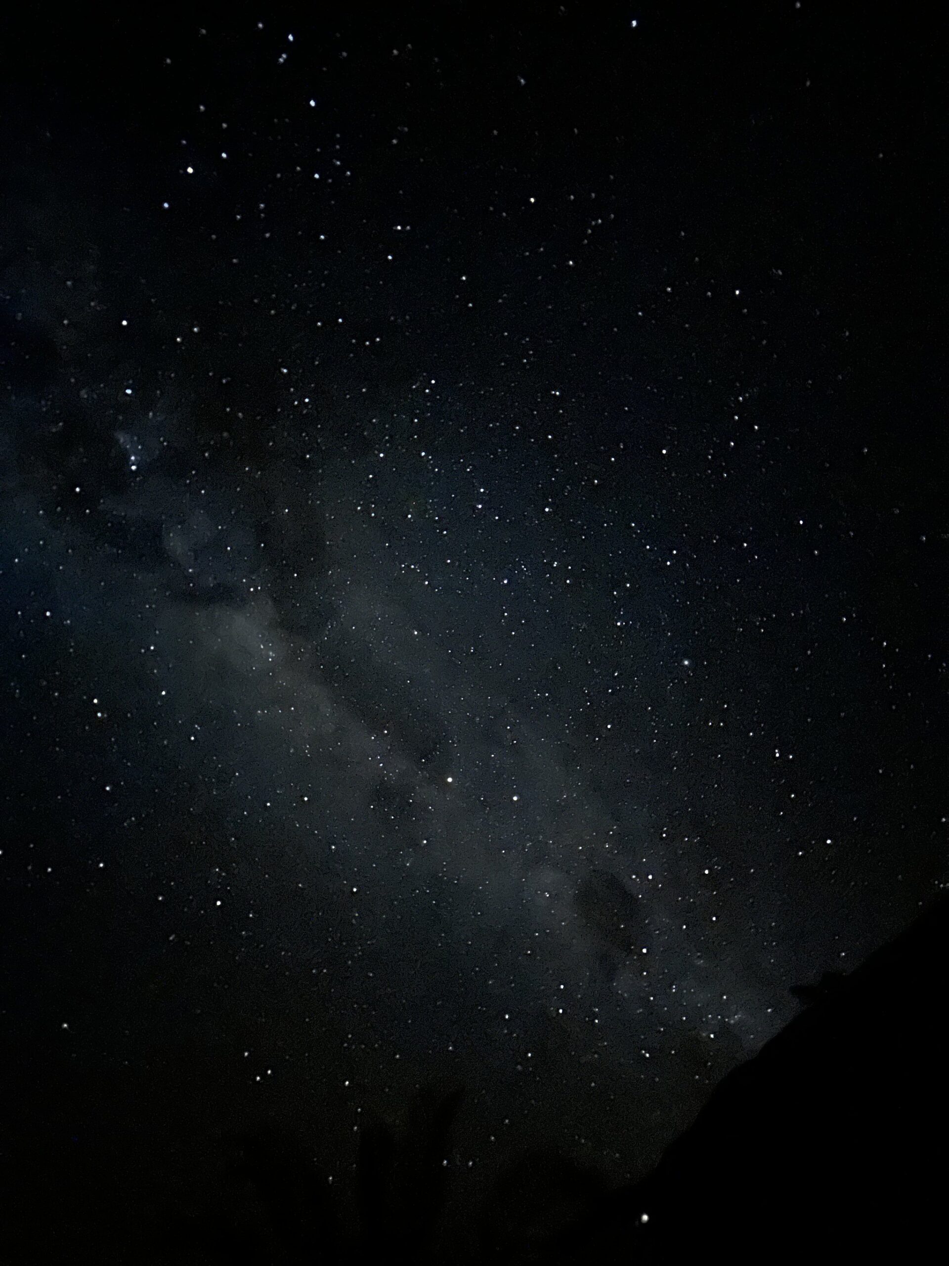 The Milky Way arching across a dark night sky on a Chapada Diamantina trip, with thousands of stars and galactic dust clouds visible above a dark silhouetted ridgeline