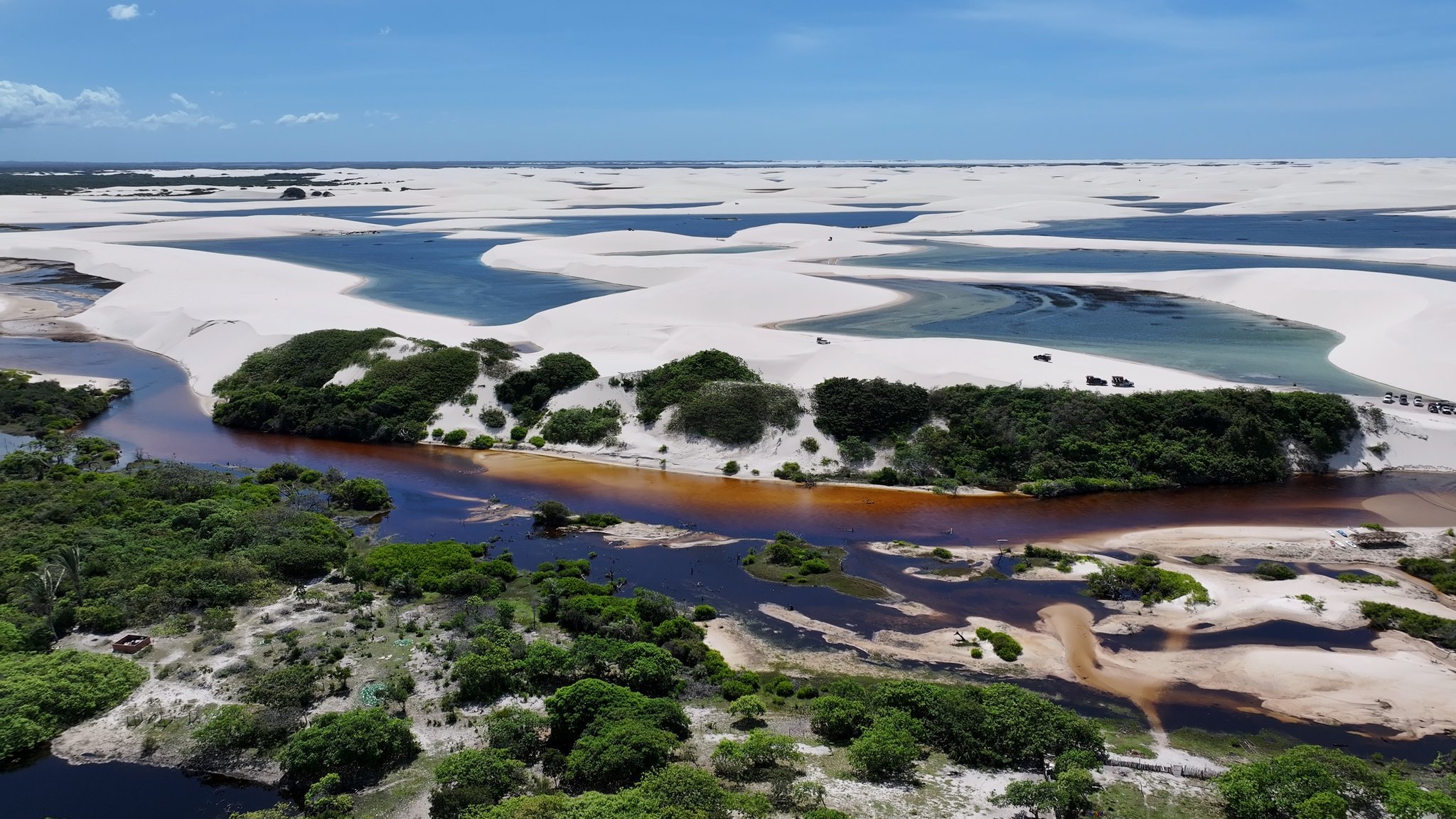 Three worlds collide: dark river, lush scrub, and a sea of white dunes stretching to the horizon. Photo: Cristian Lourenço Photo 2