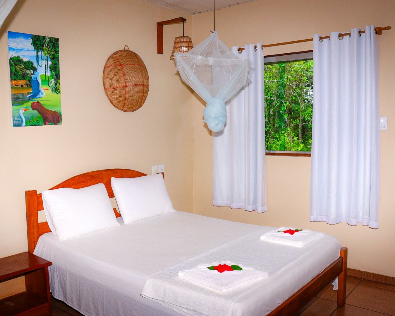 A double bed and a forest-view window make the masonry bungalow bright and restful. Bright masonry bungalow bedroom with a double bed, mosquito net and forest-view window in the Amazon