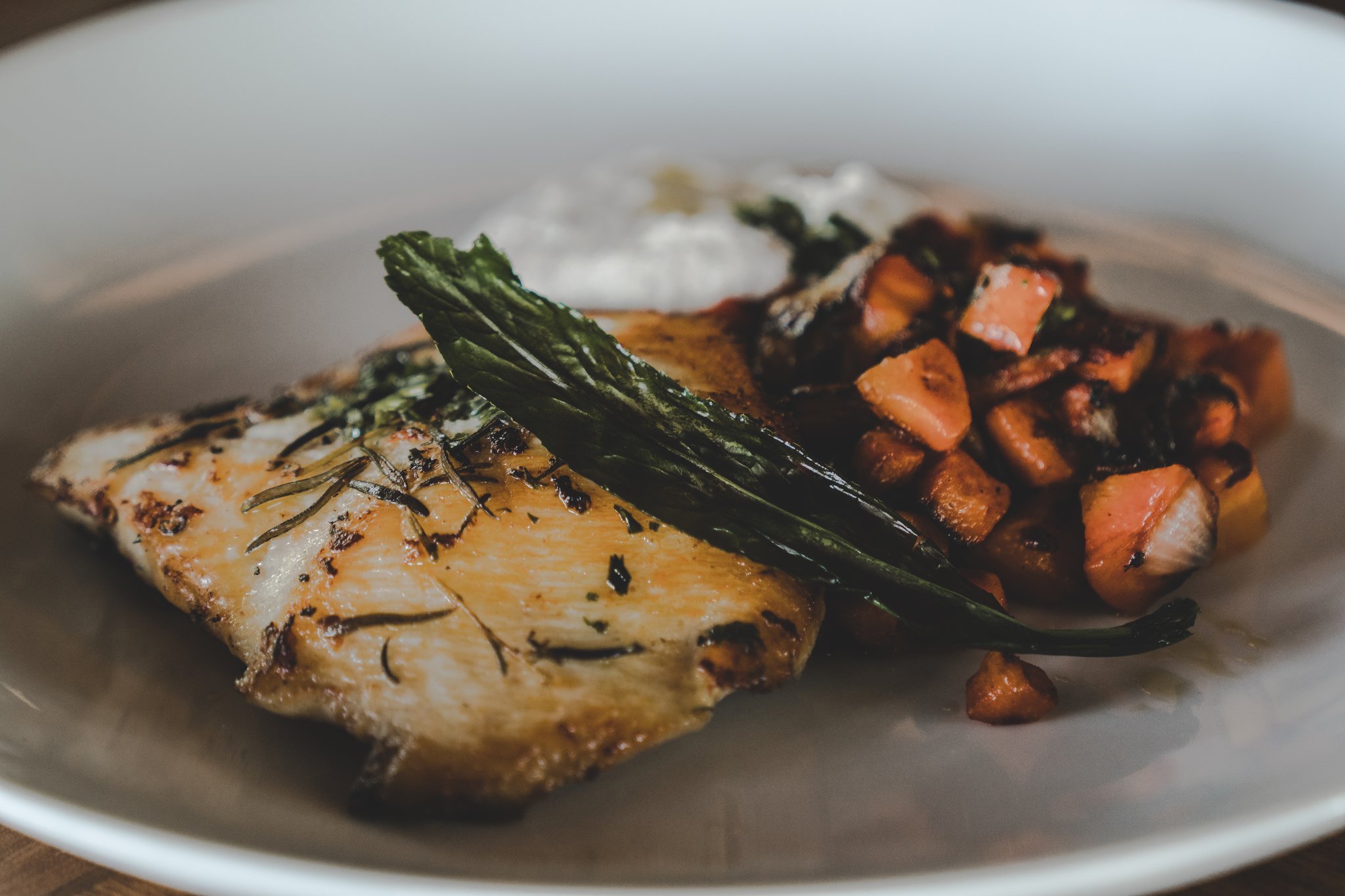 Fresh Amazonian fish, roasted with rosemary and served with seasonal vegetables — lodge dining at its finest. Herb-roasted fish fillet with wilted greens and sautéed sweet potato cubes served at Mirante do Gavião lodge restaurant