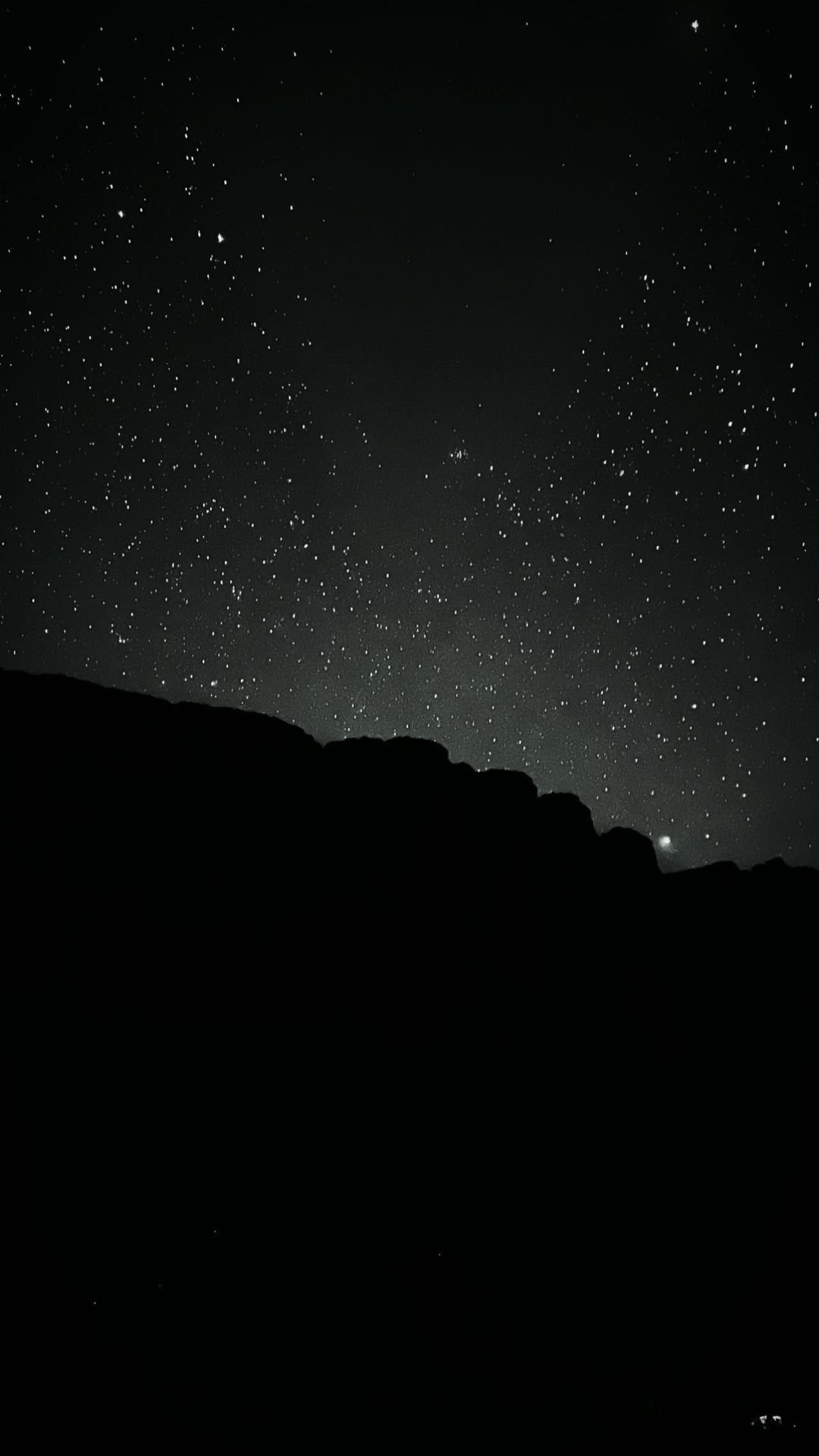 Thousands of stars fill the dark sky above the black silhouette of a rocky ridge on a mount roraima tours expedition night