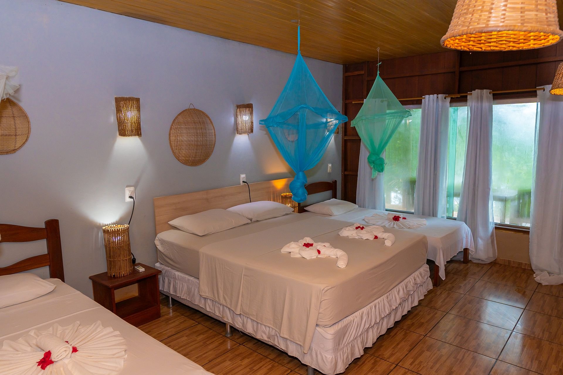 Turquoise nets and woven decor give the superior bungalow a regional touch. Superior bungalow detail with a double bed, turquoise mosquito nets and woven wall decor in the Amazon